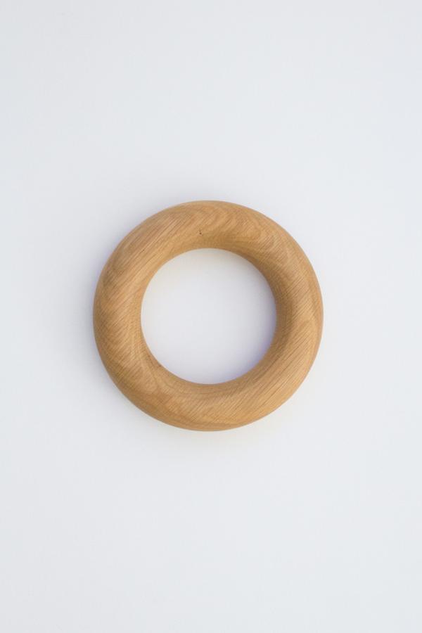 A round doughnut shaped object handmade from American Oak for styling coffee tables.