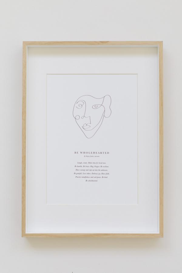 A print with a wholehearted typography message sits in an oak frame.