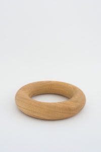 A round doughnut shaped object handmade from American Oak for styling coffee tables.