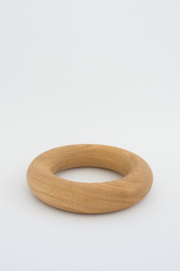 A round doughnut shaped object handmade from American Oak for styling coffee tables.