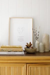 A Be Wholehearted Mantra Print in an oak frame on a sideboard.