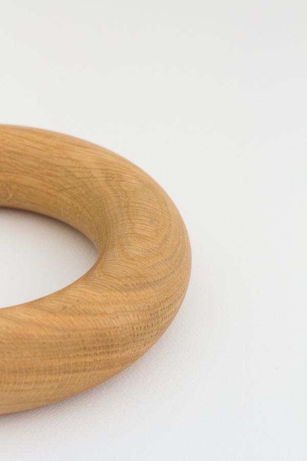 A round doughnut shaped object handmade from American Oak for styling coffee tables.