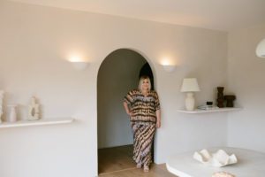 Stylist Hayley Jenkin stands in an archway surrounded by shoot props.