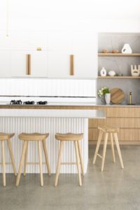Modern kitchen with floating shelving, all styled with vases, bowls and flowers.