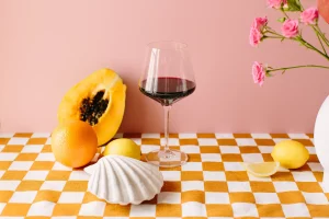 Mustard check tablecloth with a vignette of shells, wine and fruit.